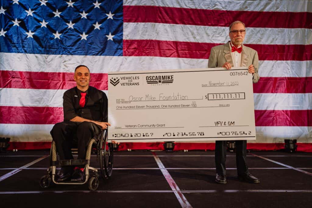 big check from Vehicles For Veterans presented to Oscar Mike Foundation